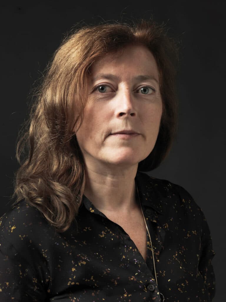 Color portrait of Dana Lixenberg wearing a black shirt and gold necklace