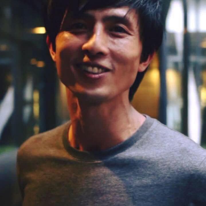 Color photo of Ian Teh smiling and looking into the camera wearing a grey shirt