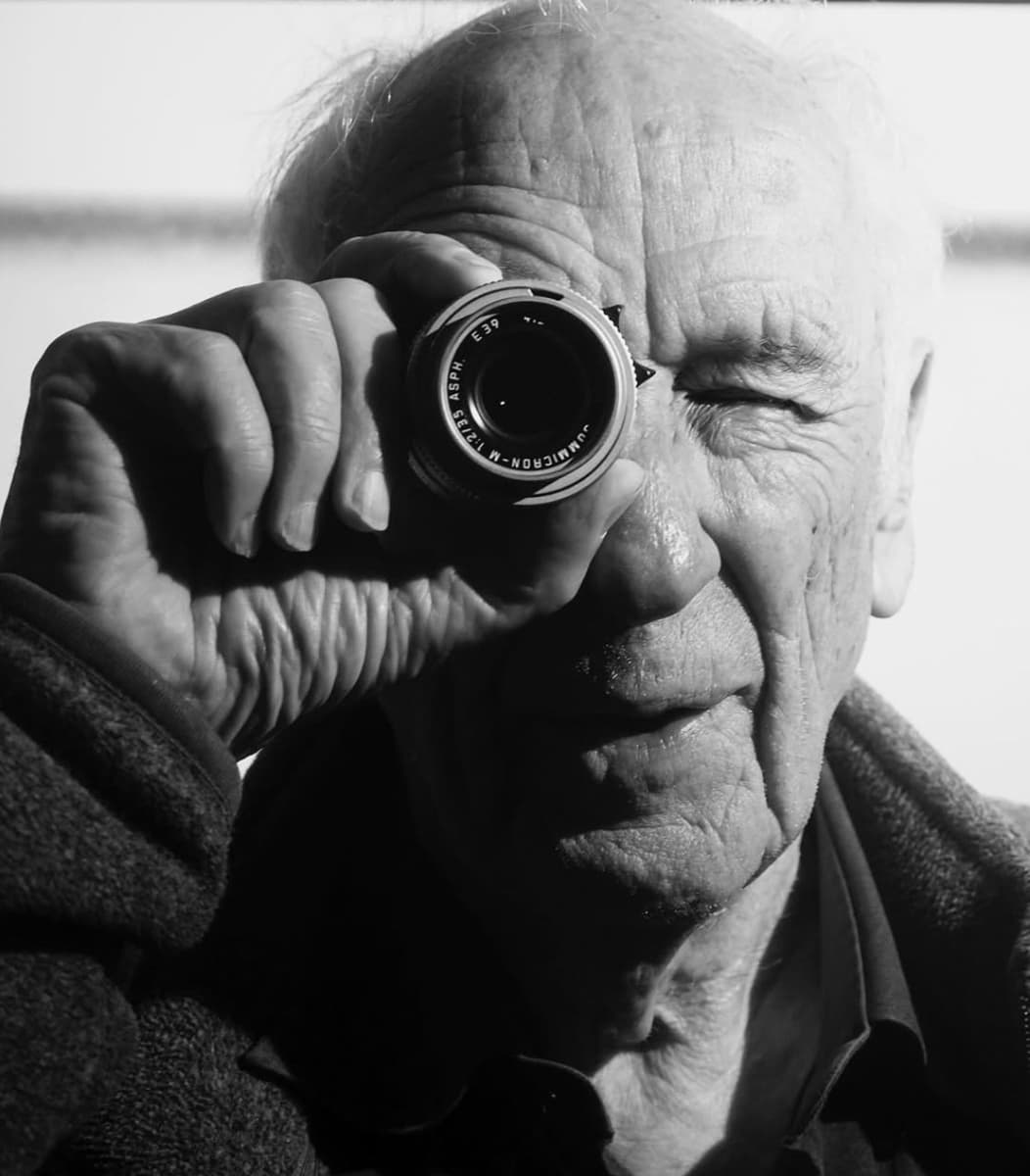 B&W portrait of Thomas Hoepker holding a viewfinder up to his right eye