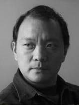 B&W portrait of Yang Junpo looking to the left and wearing a dark collared shirt