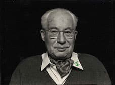 B&W portrait of Henri Storck, wearing wire frame glasses and an ascot
