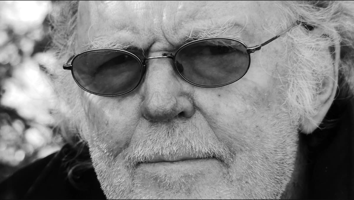 B&W close up portrait of Willem Diepraam wearing wireframe sunglasses